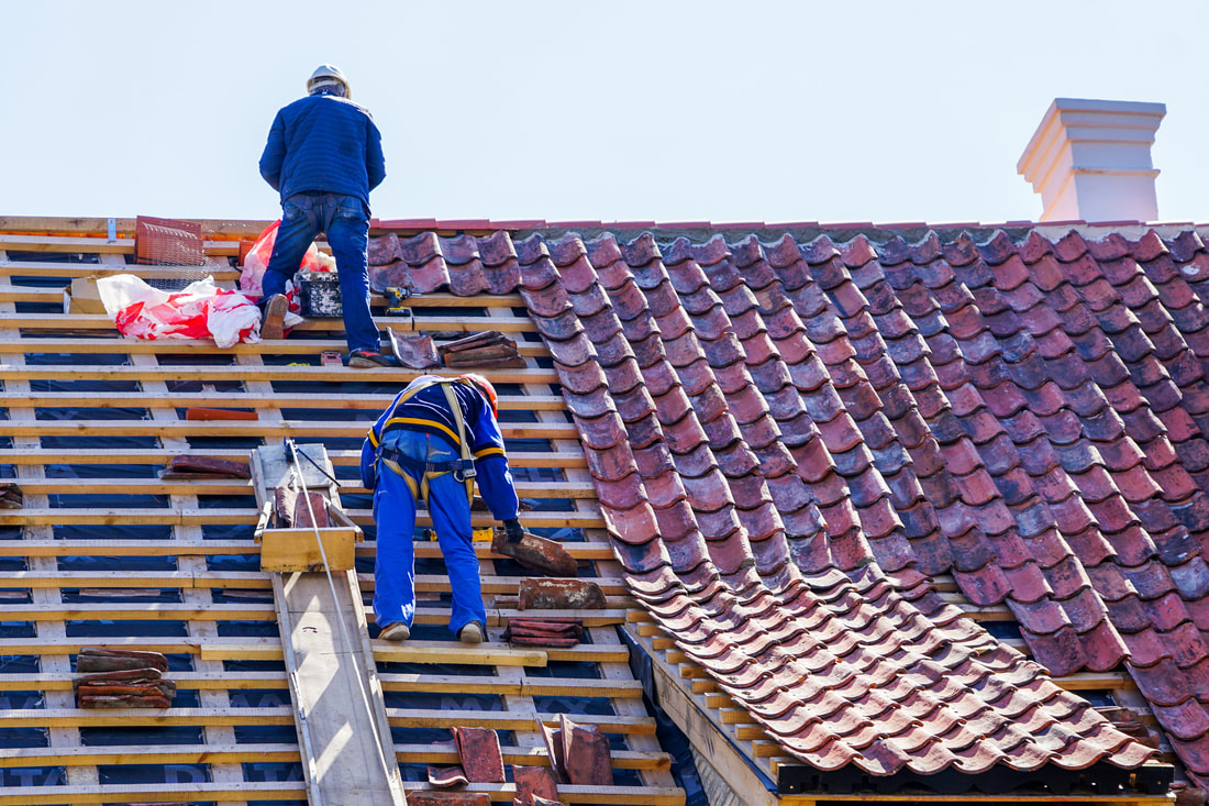 Two workers installing tile roof