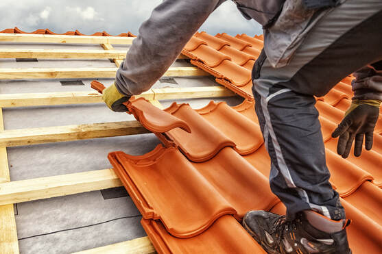 Worker placing roofing tile